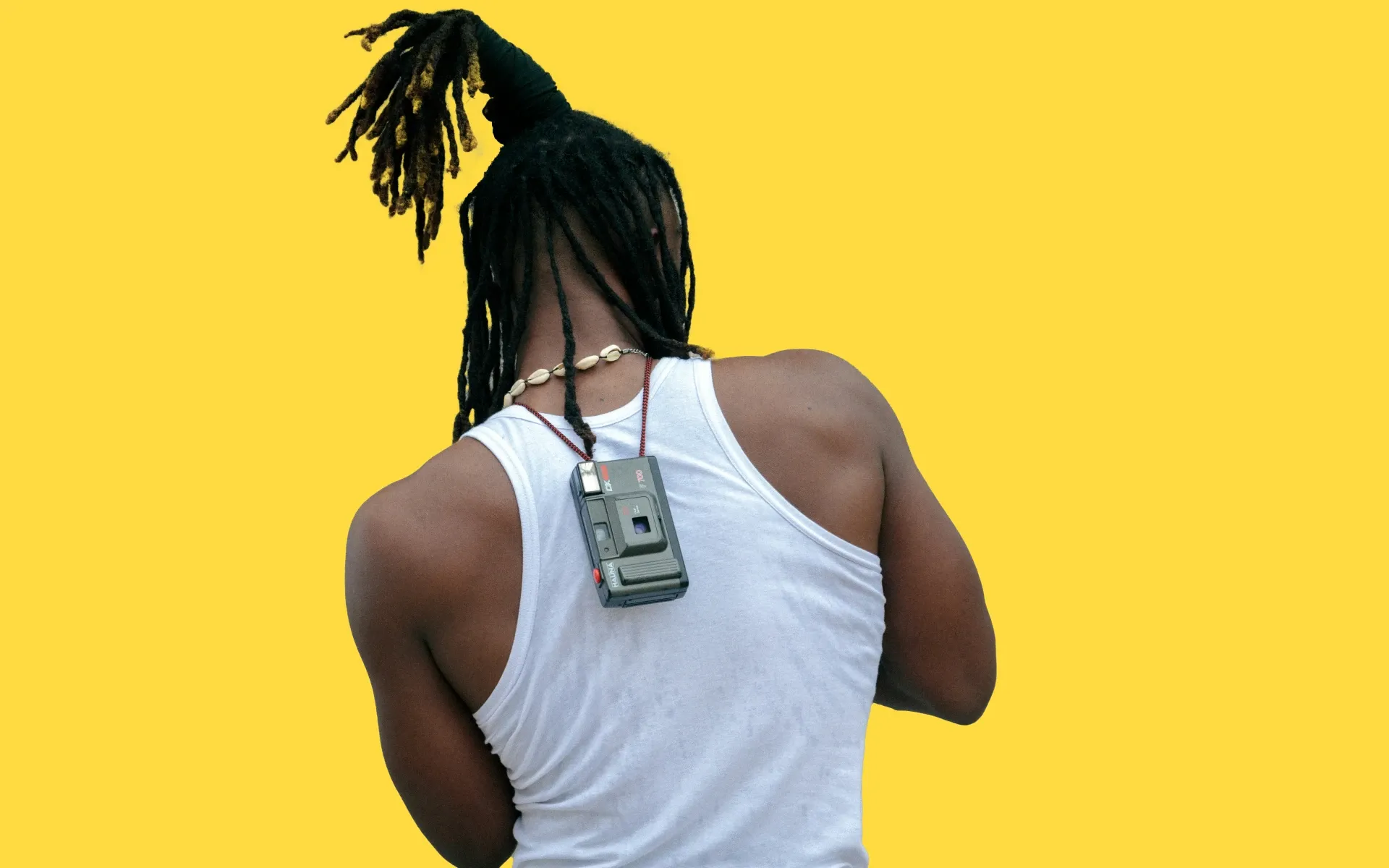 A man texting with a camera strapped around his neck