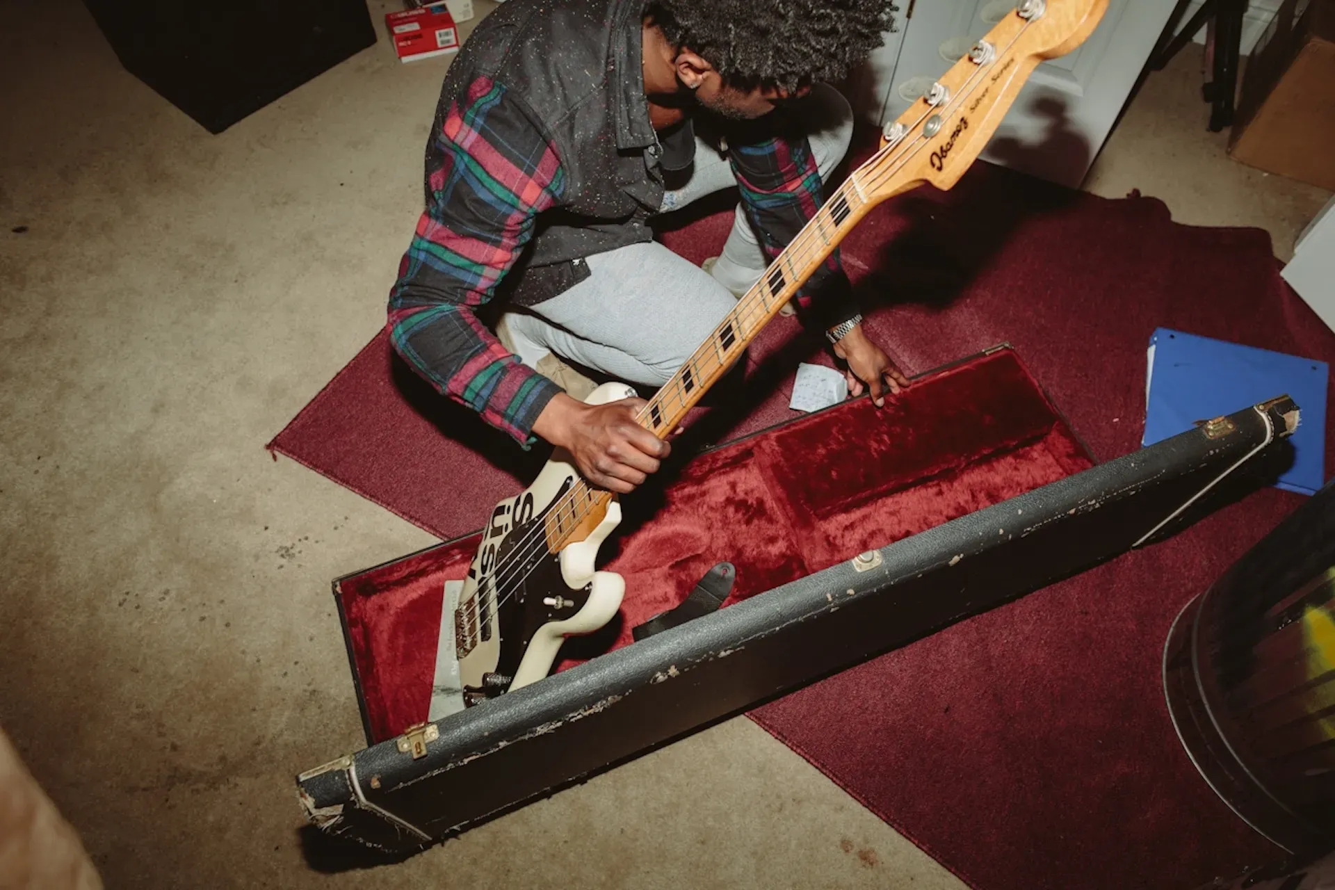 A musician taking their guitar out of its case