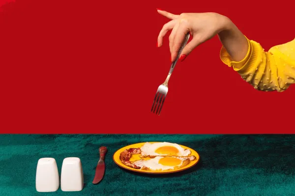 Woman about to eat bacon and eggs 